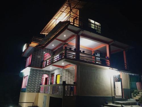 a lit up building with a balcony on it at night at The Jungle - RISHOP in Rishop
