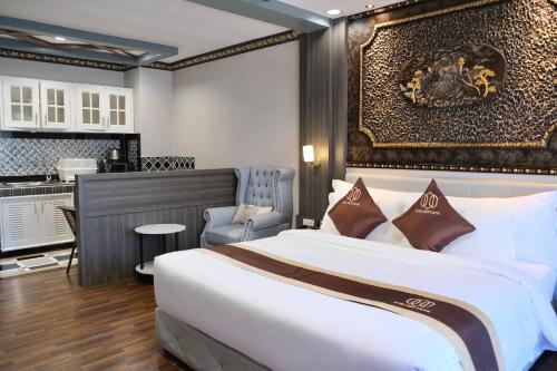 パタヤ・セントラルにあるKTK Pattaya Hotel & Residenceの大きなベッドとキッチンが備わるホテルルームです。