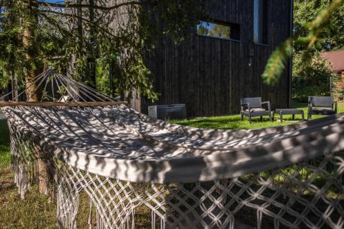 a hammock in a yard with chairs and a building at Mokre 22 in Bielsk Podlaski