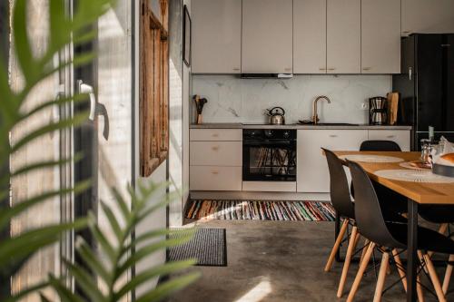 a kitchen with a table and chairs and a kitchen with white cabinets at Mokre 22 in Bielsk Podlaski