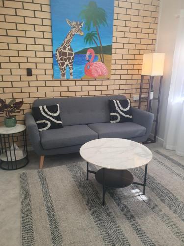 Una sala de estar con un sofá azul y una mesa. en Elliston Apartments, en Elliston