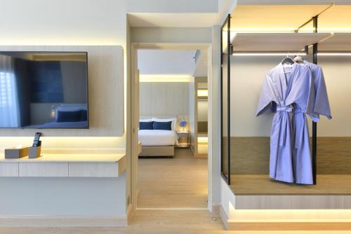曼谷Centre Point Plus Hotel Pratunam的更衣室,带衣架的浴袍
