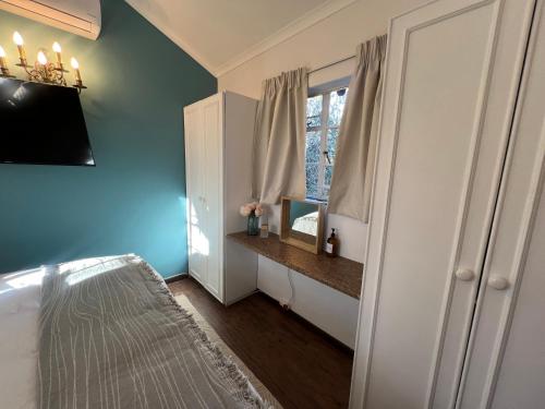 a bedroom with blue walls and a window at Die Stalle in Klerksdorp