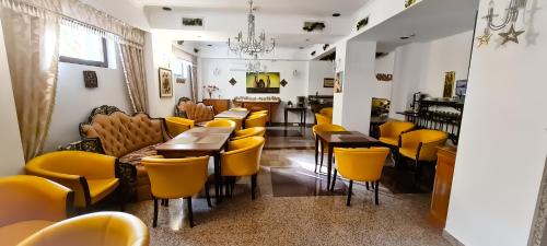 a restaurant with yellow chairs and tables in a room at Casa Michelangelo in Bucharest