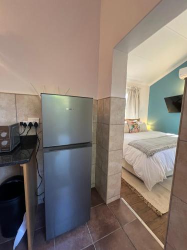 a kitchen with a refrigerator in a room with a bed at Die Stalle in Klerksdorp