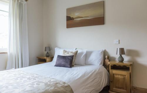 a bedroom with a bed with white sheets and pillows at Portbeg Holiday Homes at Donegal Bay in Bundoran
