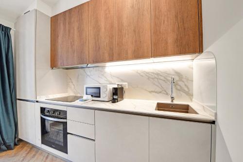 a small kitchen with a sink and a microwave at Novos Central Apartments in Lugano