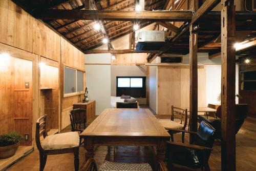 a large room with a wooden table and chairs at JUU arts&stay nishikujo-osaka in Osaka
