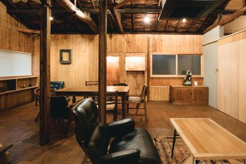 a room with a table and chairs and a dining room at JUU arts&stay nishikujo-osaka in Osaka