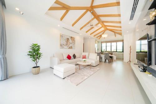 a living room with white furniture and wooden ceilings at Peykaa Estate Pool Villa by HCR in Phuket Town