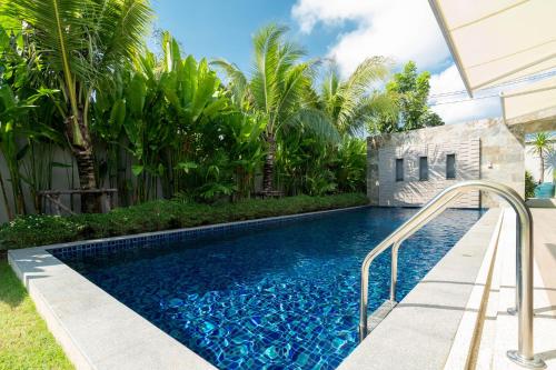 a swimming pool in a backyard with palm trees at Peykaa Estate Pool Villa by HCR in Phuket Town