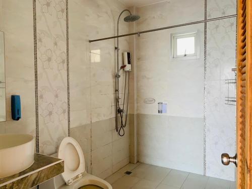 a bathroom with a shower with a toilet and a sink at Unique Pool Villa Resort in Ban Map Fakthong