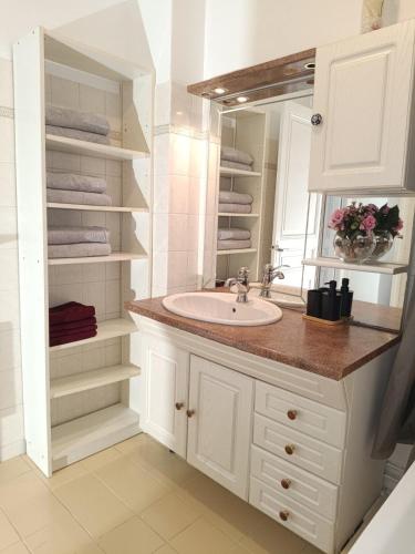 une salle de bain blanche avec un lavabo et un miroir dans l'établissement Chambres privées dans un appartement de 2 pièces à Paris 13e, à Paris