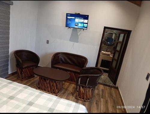 マサミトラにあるCabaña la Bonitaの椅子、テーブル、テレビが備わる客室です。