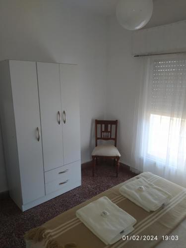 a bedroom with a bed and a cabinet and a chair at La casa in Gualeguaychú