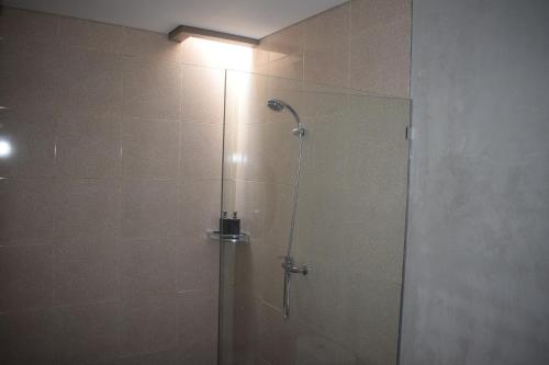 a bathroom with a shower with a glass door at Werkudara Guest House in Ubud