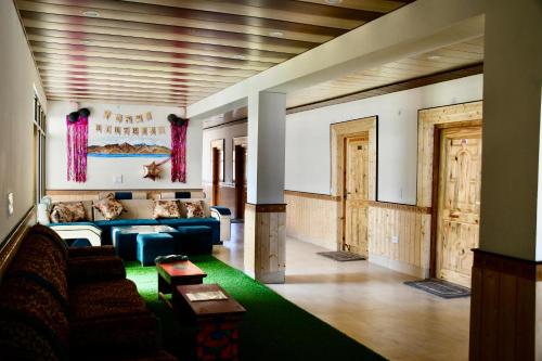 a living room with a couch and a green rug at Grand Himalaya Homestay Pangong by LexStays in Meruk
