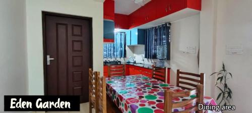 a dining room with a table and a kitchen at Eden Gardens Vagamon in Vagamon