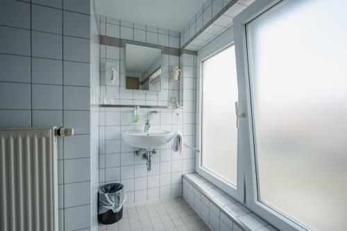 a bathroom with a sink and a window at Hotel Mirage in Duisburg