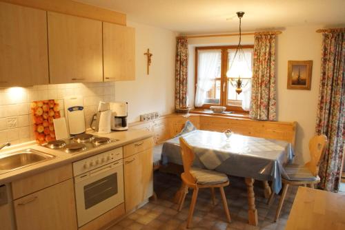 a kitchen with a sink and a table with a tablecloth at Ferienwohnung Milz in Obermaiselstein