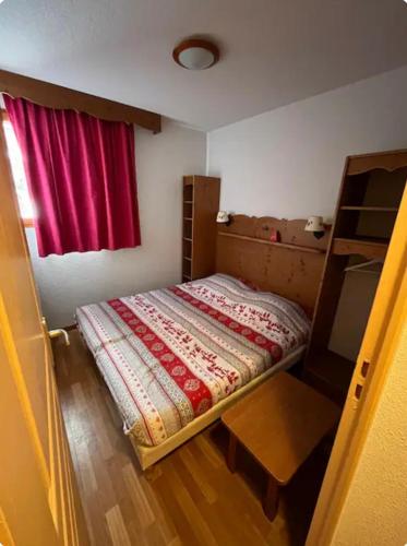 - une petite chambre avec un lit et une fenêtre rouge dans l'établissement Appartement 6 personnes à Puy-Saint-Vincent, à Puy-Saint-Vincent
