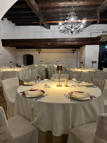 a dining room with white tables and chairs and a chandelier at Villa Maria in Belvedere di Spinello