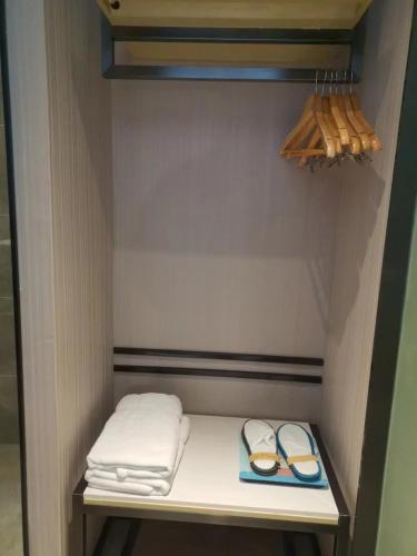 a small closet with a shelf with towels and shoes at Echarm Hotel Fengcheng Fengshui Lake in Sunjiadu