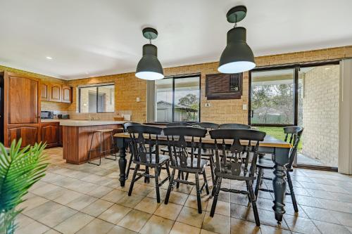 a kitchen and dining room with a table and chairs at The Vintage Beach House in Dawesville