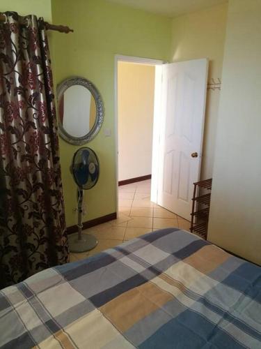 a bedroom with a bed and a mirror and a door at Lovely 1 bedroom apartment in Grand Bay, around 5 mins walk to the beach in Grand Baie