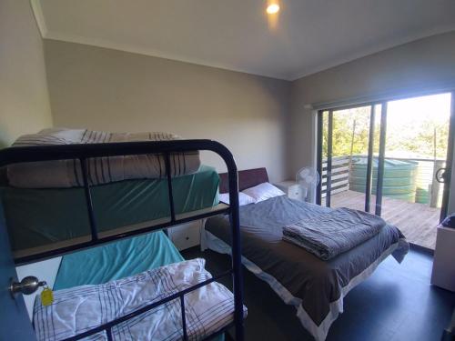 a room with two bunk beds and a balcony at 13th Apostle Accommodation in Princetown