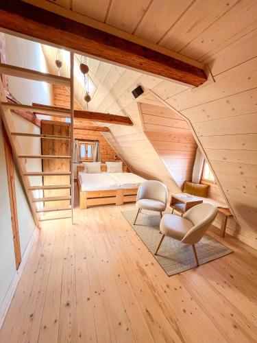 a attic bedroom with a bed and a chair at Boutique Cottage Tkalcovna in Rokytnice nad Jizerou