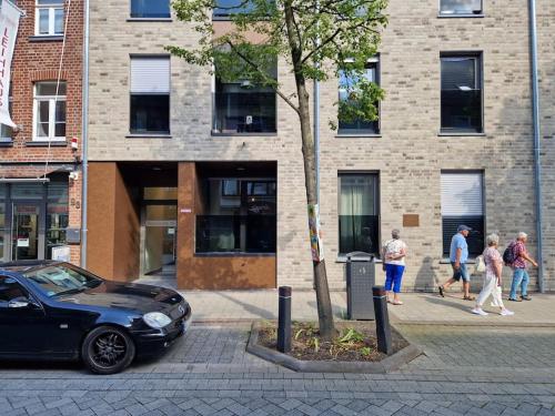 a black car parked next to a tree in front of a building at City-Juwel - Luxus Ferienwohnung in Heinsberg