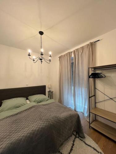 a bedroom with a bed and a chandelier at City-Juwel - Luxus Ferienwohnung in Heinsberg
