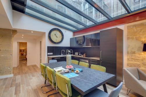 une salle à manger avec une table et une horloge au mur dans l'établissement Sweett - Sentier, à Paris