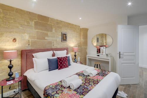 une chambre avec un grand lit avec des oreillers dans l'établissement Sweett - Sentier, à Paris