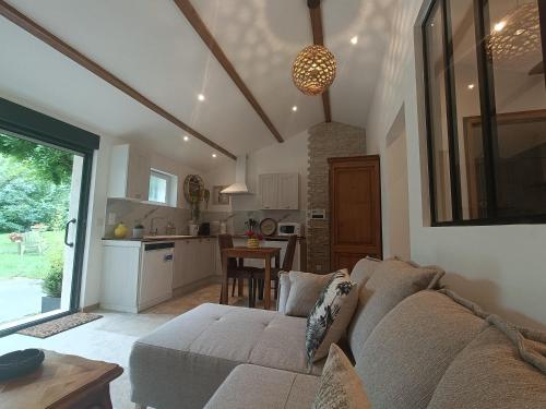 un salon avec un canapé et une cuisine dans l'établissement Gîte T2 au mas Aguilhon, à Saint-Marcel-dʼArdèche