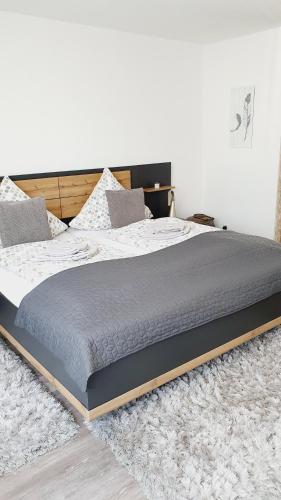 a large bed sitting on a rug in a bedroom at Ferienwohnungen Naturzeit in Willingen