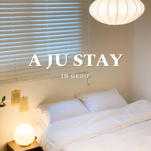Un dormitorio con un cartel de "Ju Stay" en la pared. en Aju stay Geoje, en Geoje