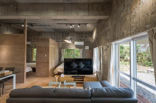 a living room with a couch and a tv at ダイバーズヴィラYoNNER in Aguni