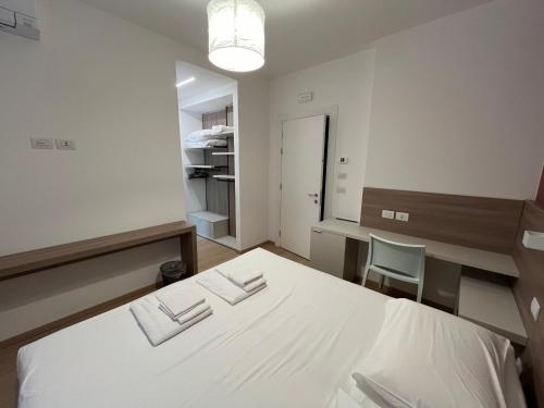 a bedroom with a bed and a desk and a chair at Hotel Al Pescatore in Duino