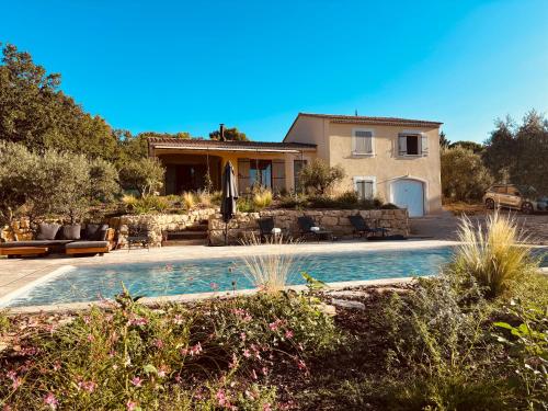 une maison avec une piscine devant une maison dans l'établissement Mas de la canopée-Luberon, à Saint-Saturnin-lès-Apt