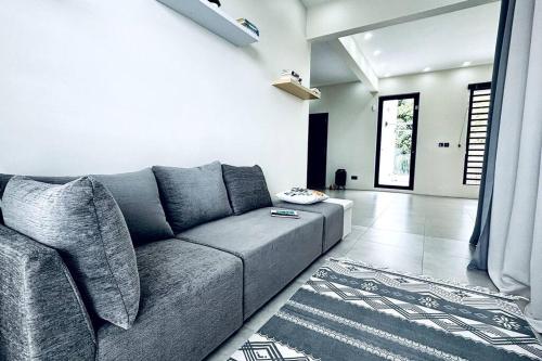 a living room with a gray couch and a rug at Sublima Villa, Luxe et élégance in La Gaulette