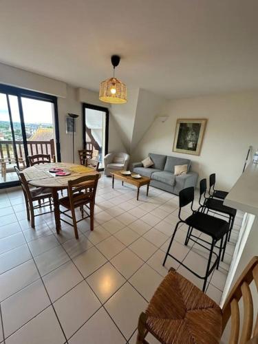 un salon avec un canapé, une table et des chaises dans l'établissement קסם משפחתי, à Blonville-sur-Mer