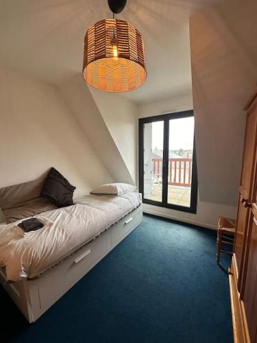 une chambre avec un lit et une grande fenêtre dans l'établissement קסם משפחתי, à Blonville-sur-Mer