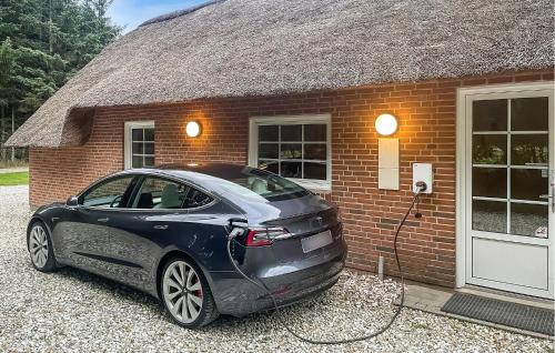 a car is plugged into a brick house at Lovely Home In Ulfborg With Sauna in Ulfborg