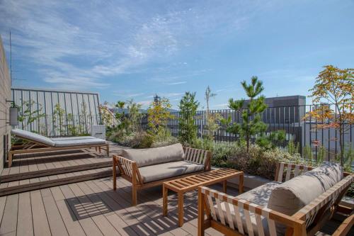 a patio with benches and chairs on a balcony at Park Hotel Kyoto in Kyoto