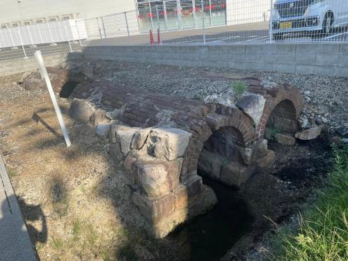 an old brick bridge with a river in a yard at かなわアパートメントステイ201 in Tsuruga