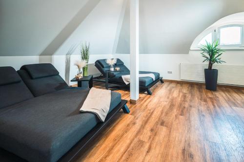 a living room with a bed and a chair at martas Hotel Lutherstadt Wittenberg in Lutherstadt Wittenberg