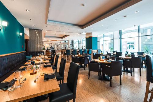 a restaurant with wooden tables and chairs at martas Hotel Lutherstadt Wittenberg in Lutherstadt Wittenberg