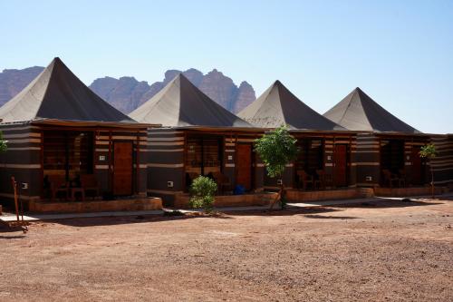 a group of large black and white tents at Hasan Zawaideh Camp in Wadi Rum